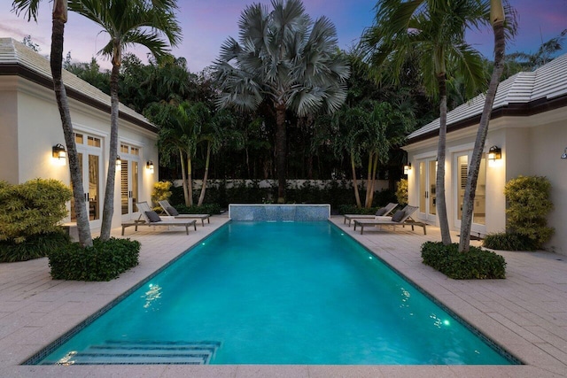 pool at dusk with a patio