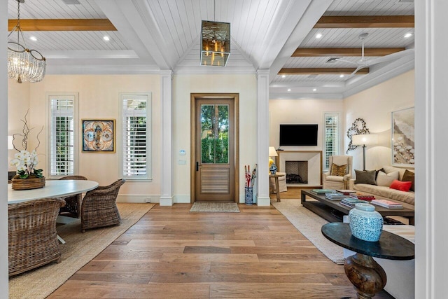 entrance foyer with beamed ceiling, wood ceiling, a chandelier, ornamental molding, and hardwood / wood-style flooring