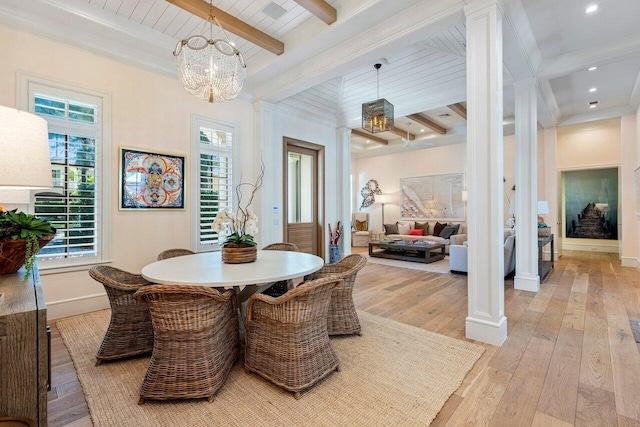 dining room featuring decorative columns, an inviting chandelier, beam ceiling, and light hardwood / wood-style floors