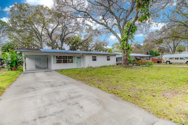 view of front of home with a front yard and a carport