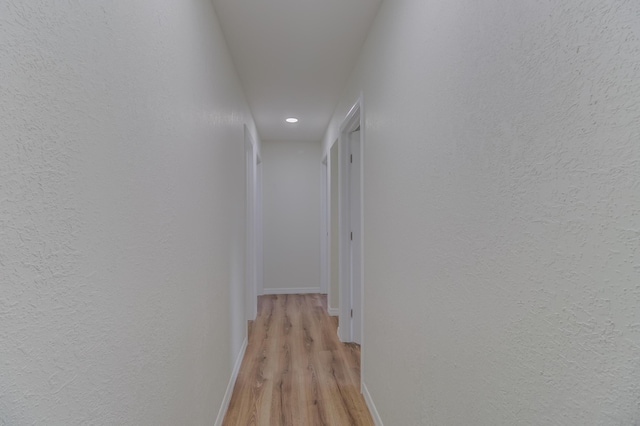 corridor with light hardwood / wood-style flooring