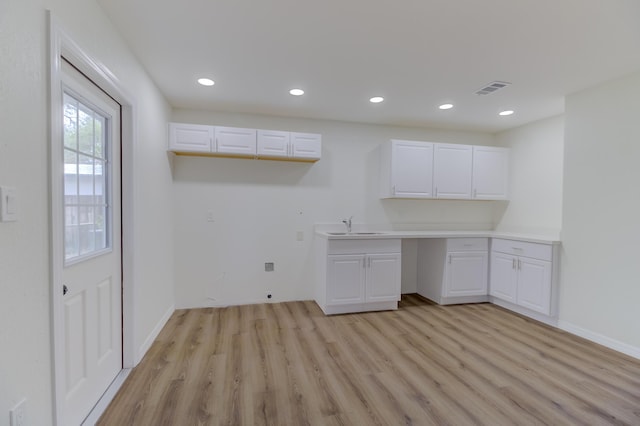 laundry area with sink and light hardwood / wood-style floors