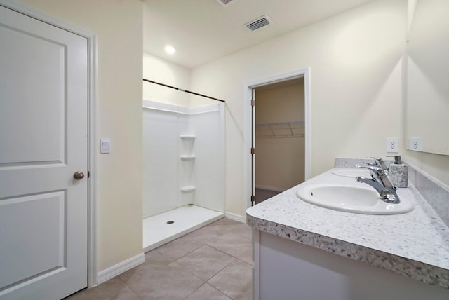 bathroom featuring vanity, tile patterned floors, and walk in shower