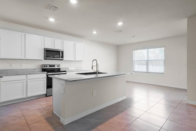 kitchen with an island with sink, appliances with stainless steel finishes, sink, and white cabinets