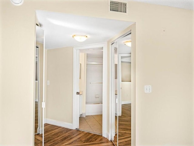 hallway with hardwood / wood-style flooring