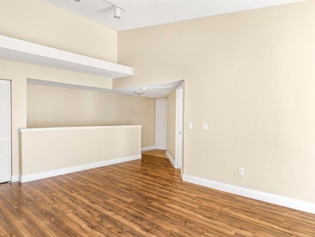 spare room with hardwood / wood-style flooring and track lighting