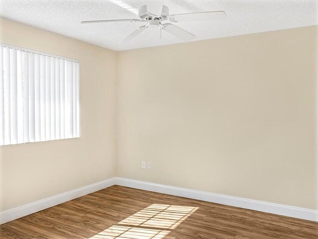 spare room featuring wood-type flooring, ceiling fan, and a textured ceiling