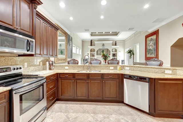 kitchen featuring sink, ornamental molding, kitchen peninsula, stainless steel appliances, and decorative backsplash