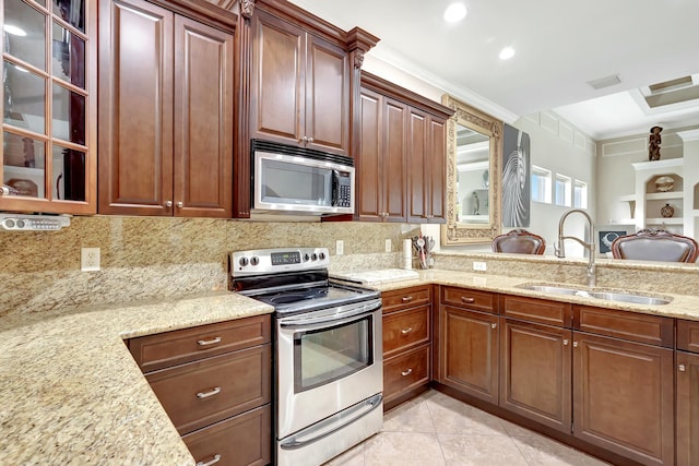 kitchen featuring appliances with stainless steel finishes, sink, decorative backsplash, light stone counters, and crown molding