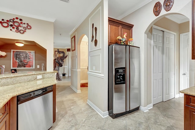 kitchen with crown molding, appliances with stainless steel finishes, and light stone counters