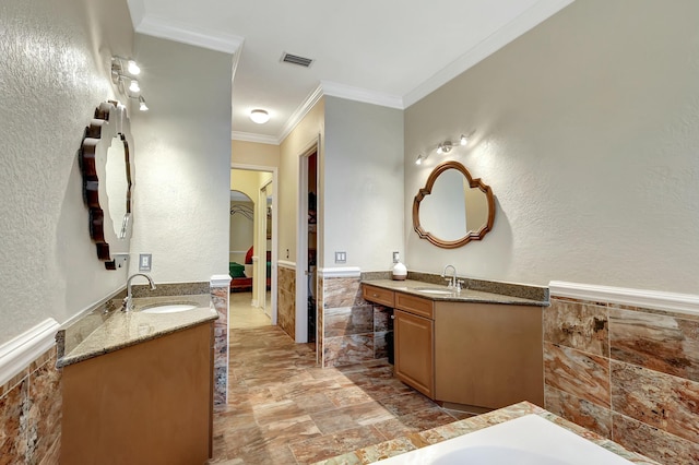 bathroom with crown molding, tile walls, and vanity