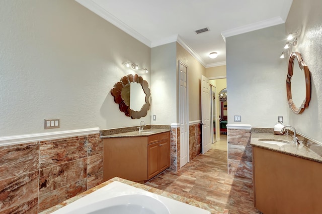 bathroom with vanity, ornamental molding, a bathing tub, and tile walls