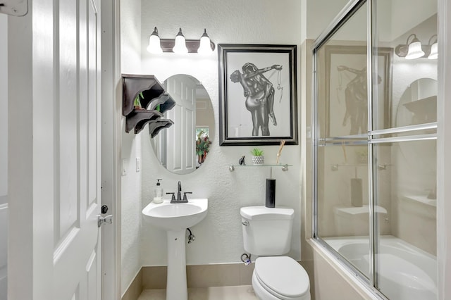 bathroom featuring toilet and combined bath / shower with glass door