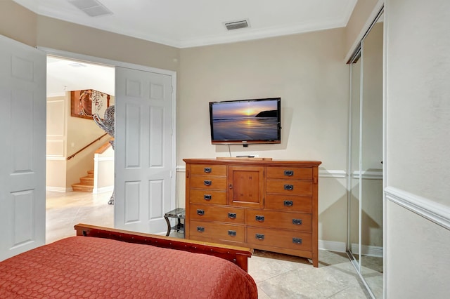 bedroom featuring ornamental molding, light tile patterned floors, and a closet