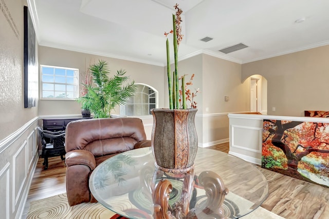 living area with ornamental molding and light hardwood / wood-style flooring