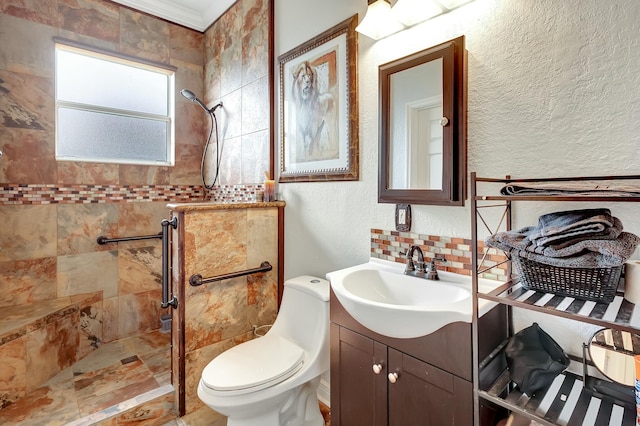 bathroom featuring vanity, a tile shower, crown molding, and toilet