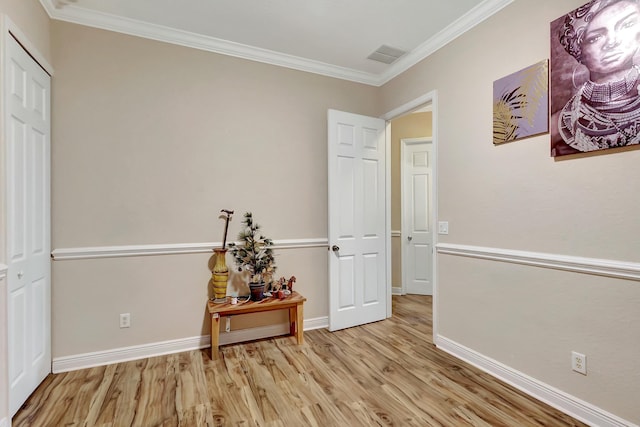 interior space featuring ornamental molding and light hardwood / wood-style flooring