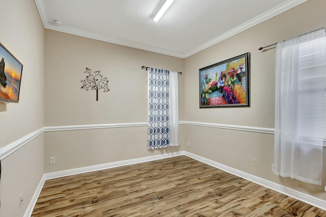 unfurnished room featuring hardwood / wood-style flooring, ornamental molding, and a textured ceiling