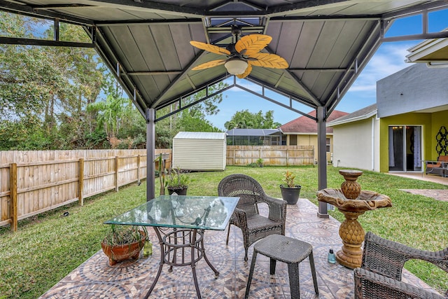 view of patio with ceiling fan and a shed