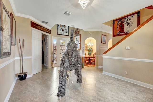 hallway with crown molding, a textured ceiling, a chandelier, and french doors