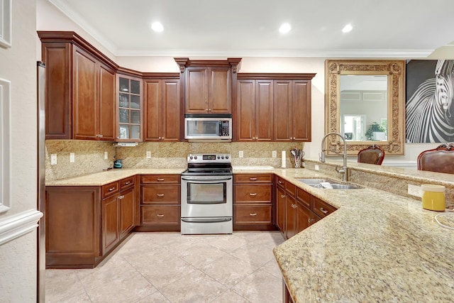 kitchen featuring stainless steel appliances, ornamental molding, light stone countertops, and sink