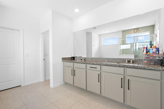 bathroom featuring a shower with door, vanity, and tile patterned floors