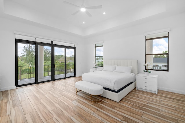 bedroom with a raised ceiling, access to exterior, ceiling fan, and french doors