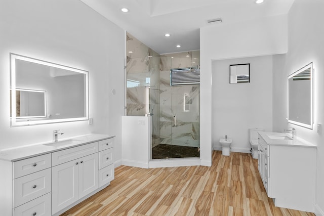 bathroom featuring toilet, an enclosed shower, wood-type flooring, a bidet, and vanity