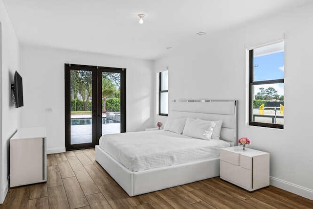 bedroom with wood-type flooring, access to outside, and french doors