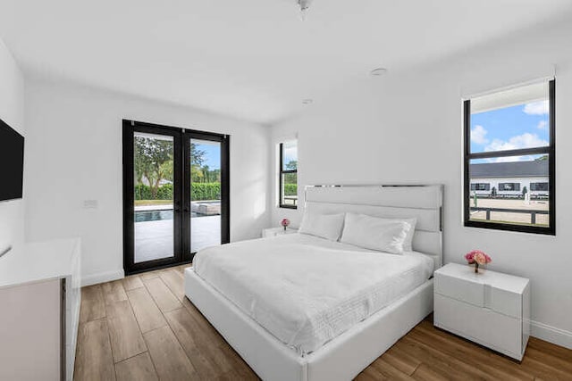 bedroom with hardwood / wood-style flooring, access to outside, and french doors