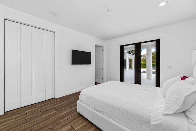 bedroom with french doors, access to exterior, dark hardwood / wood-style flooring, and a closet