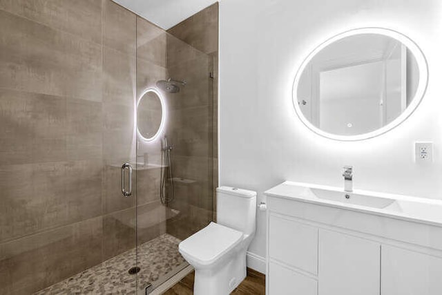 bathroom featuring an enclosed shower, vanity, and toilet