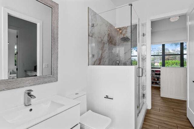 bathroom featuring vanity, wood-type flooring, toilet, and walk in shower