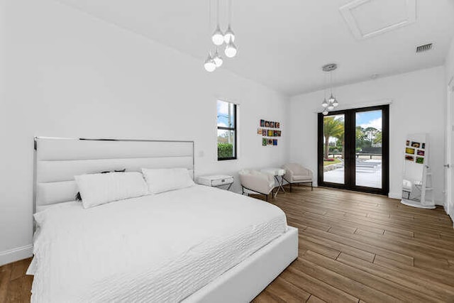 bedroom featuring access to exterior, dark hardwood / wood-style floors, and french doors