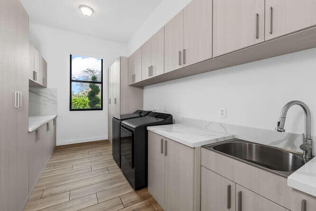 laundry area featuring cabinets, sink, and washer and dryer