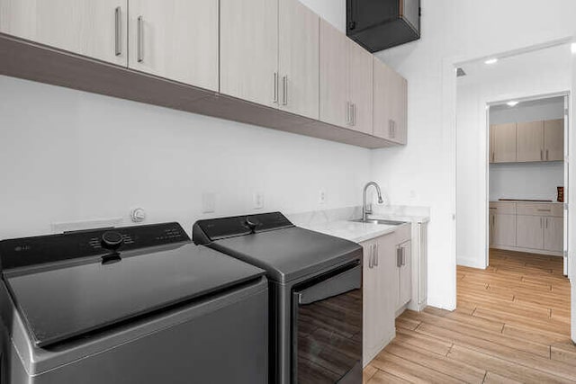 laundry room featuring cabinets, sink, and washer and dryer