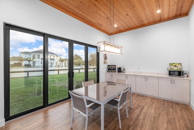 dining area featuring wood ceiling, crown molding, and light wood-type flooring