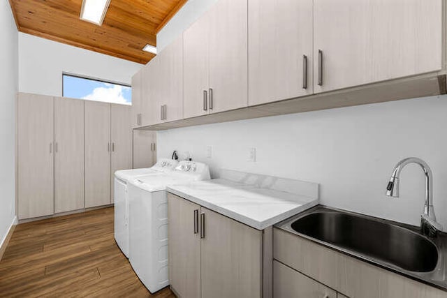 laundry room featuring dark hardwood / wood-style floors, sink, cabinets, wood ceiling, and washer and clothes dryer