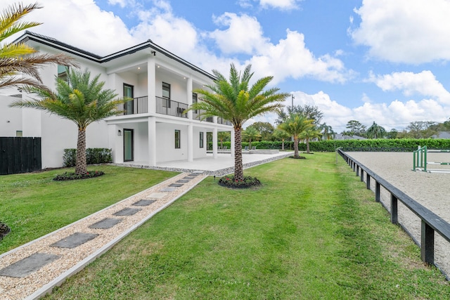 exterior space featuring a balcony and a lawn