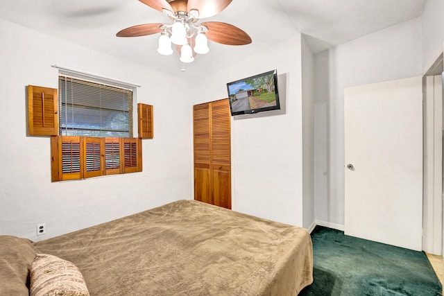 carpeted bedroom with ceiling fan and a closet