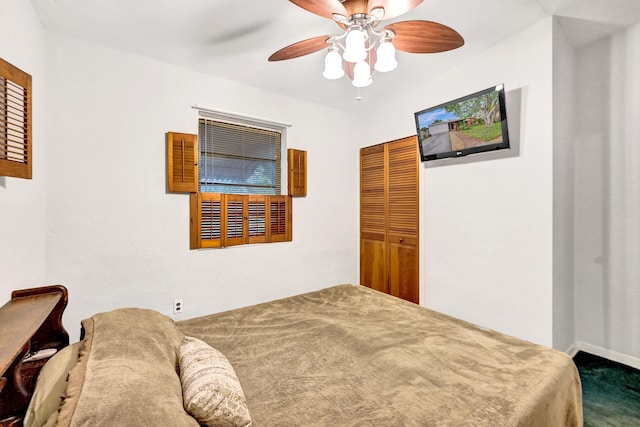 carpeted bedroom with ceiling fan and a closet