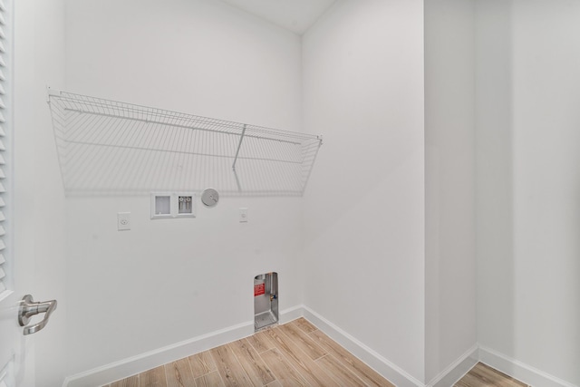 clothes washing area featuring hardwood / wood-style floors, hookup for a washing machine, hookup for an electric dryer, and hookup for a gas dryer