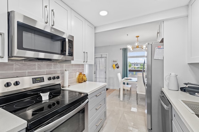 kitchen with white cabinetry, backsplash, pendant lighting, and appliances with stainless steel finishes