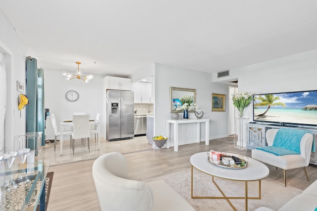 living room featuring a chandelier and light hardwood / wood-style floors