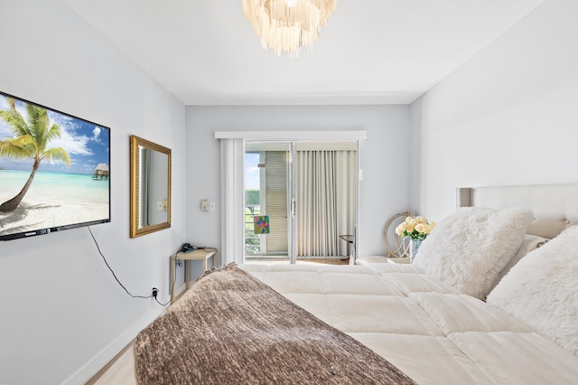 bedroom with access to outside and a chandelier