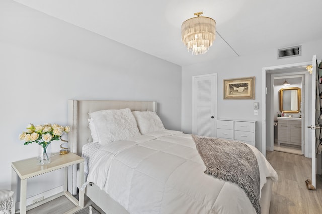 bedroom featuring an inviting chandelier and light wood-type flooring