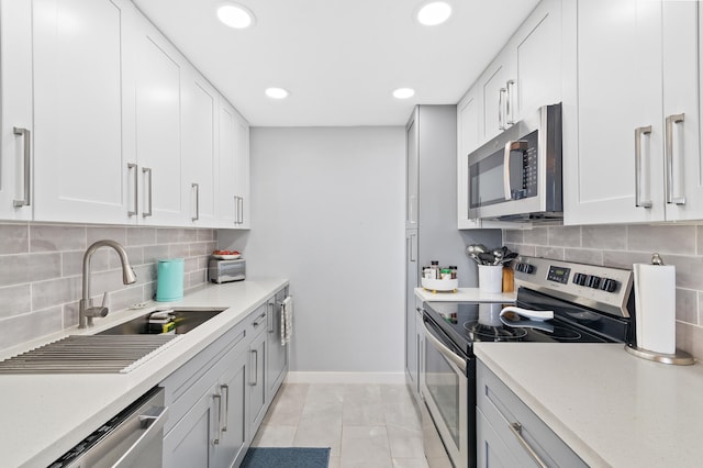 kitchen featuring backsplash, appliances with stainless steel finishes, sink, and white cabinets