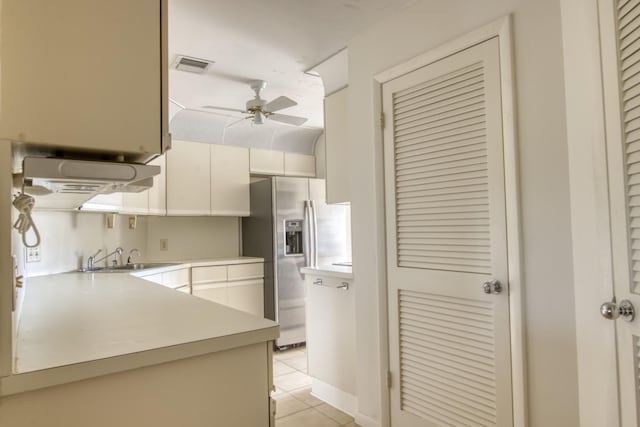 kitchen with light tile patterned flooring, white cabinetry, sink, ceiling fan, and stainless steel fridge with ice dispenser