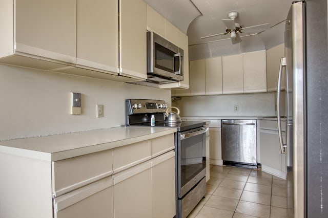 kitchen with light tile patterned flooring, ceiling fan, appliances with stainless steel finishes, and cream cabinets