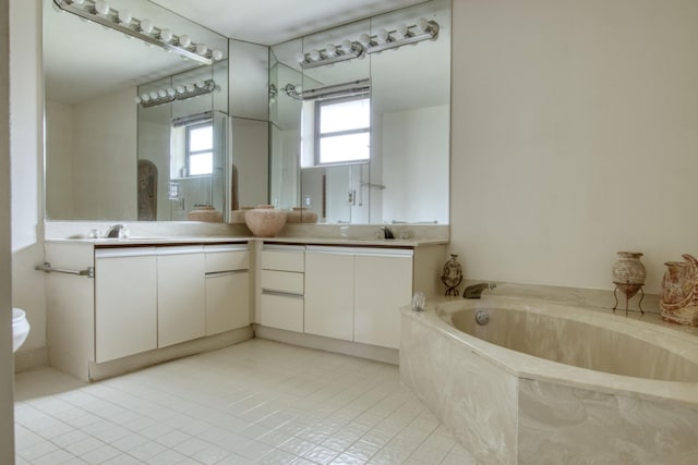 bathroom with tile patterned flooring, vanity, and a tub